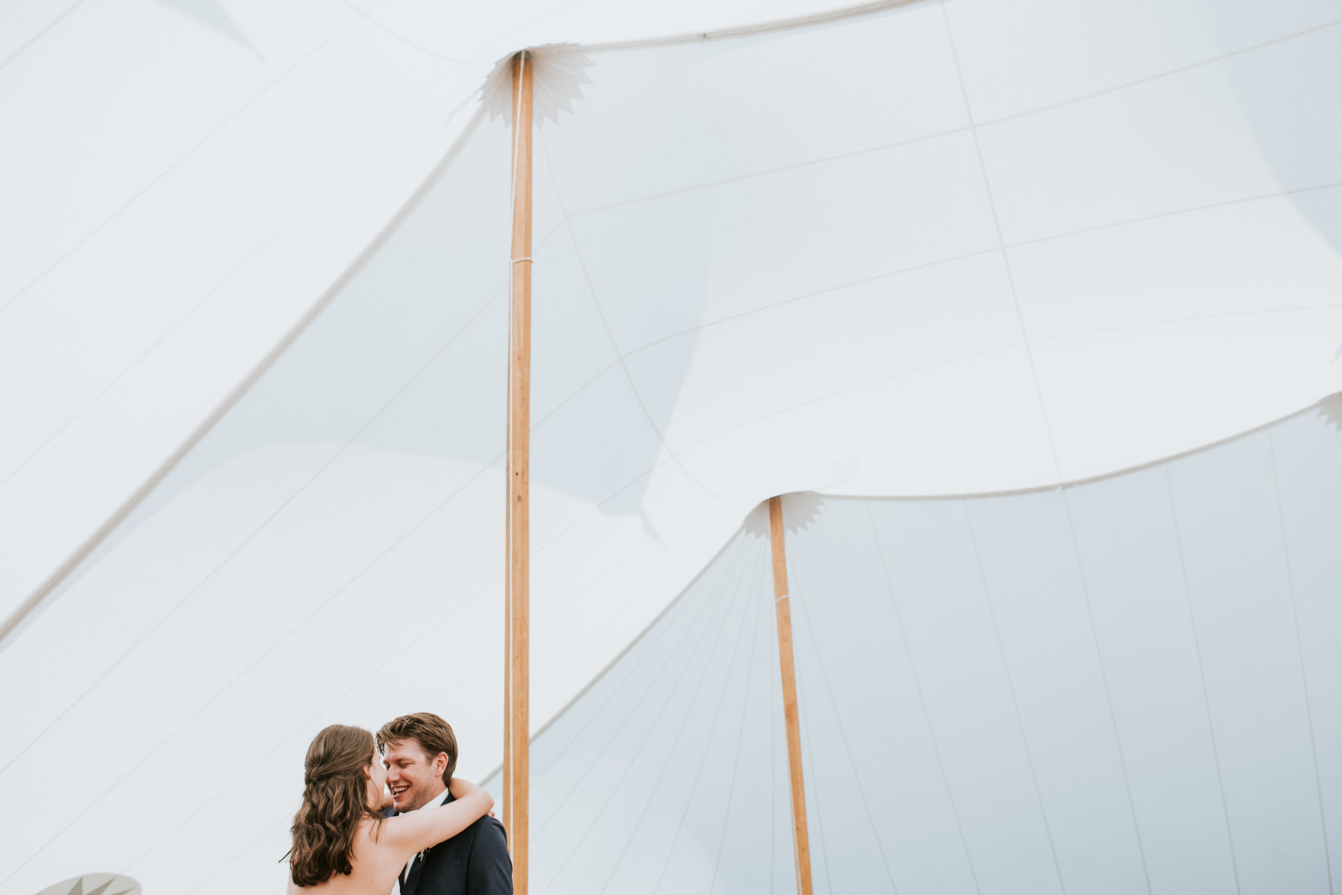 bride and groom dancing inside sail cloth tent