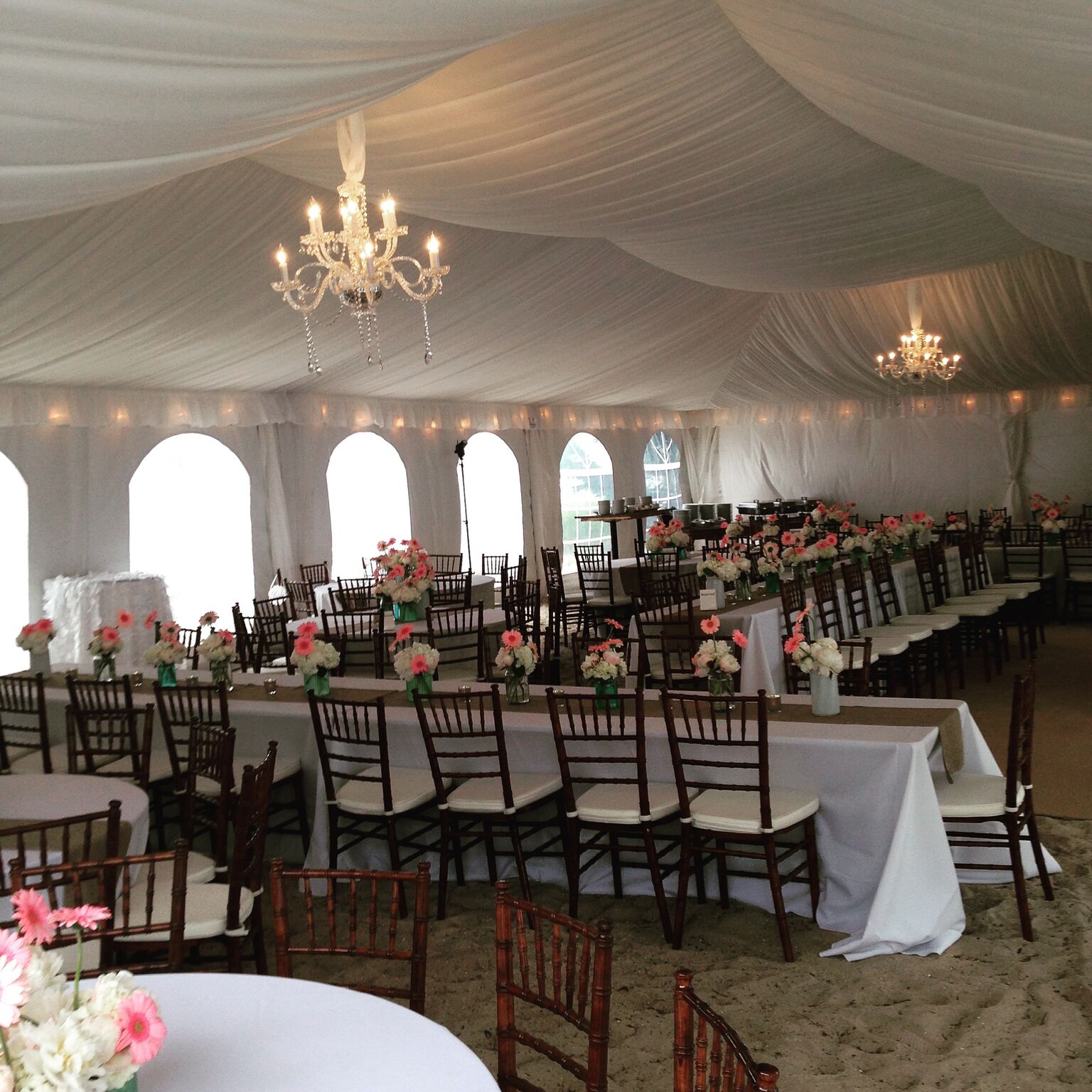 long wedding tables with pink and white flowers under a tent