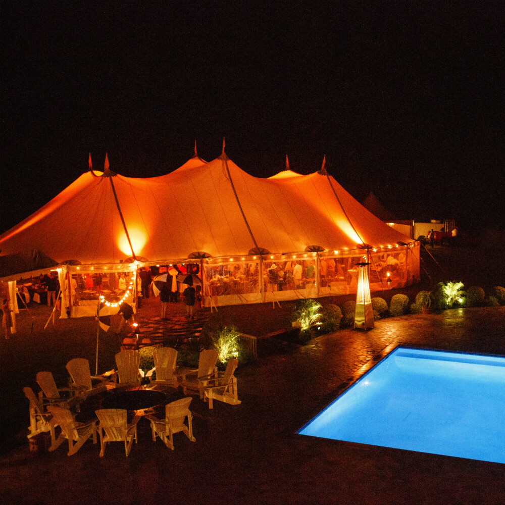 Giant tent beside a swimming pool and firepit