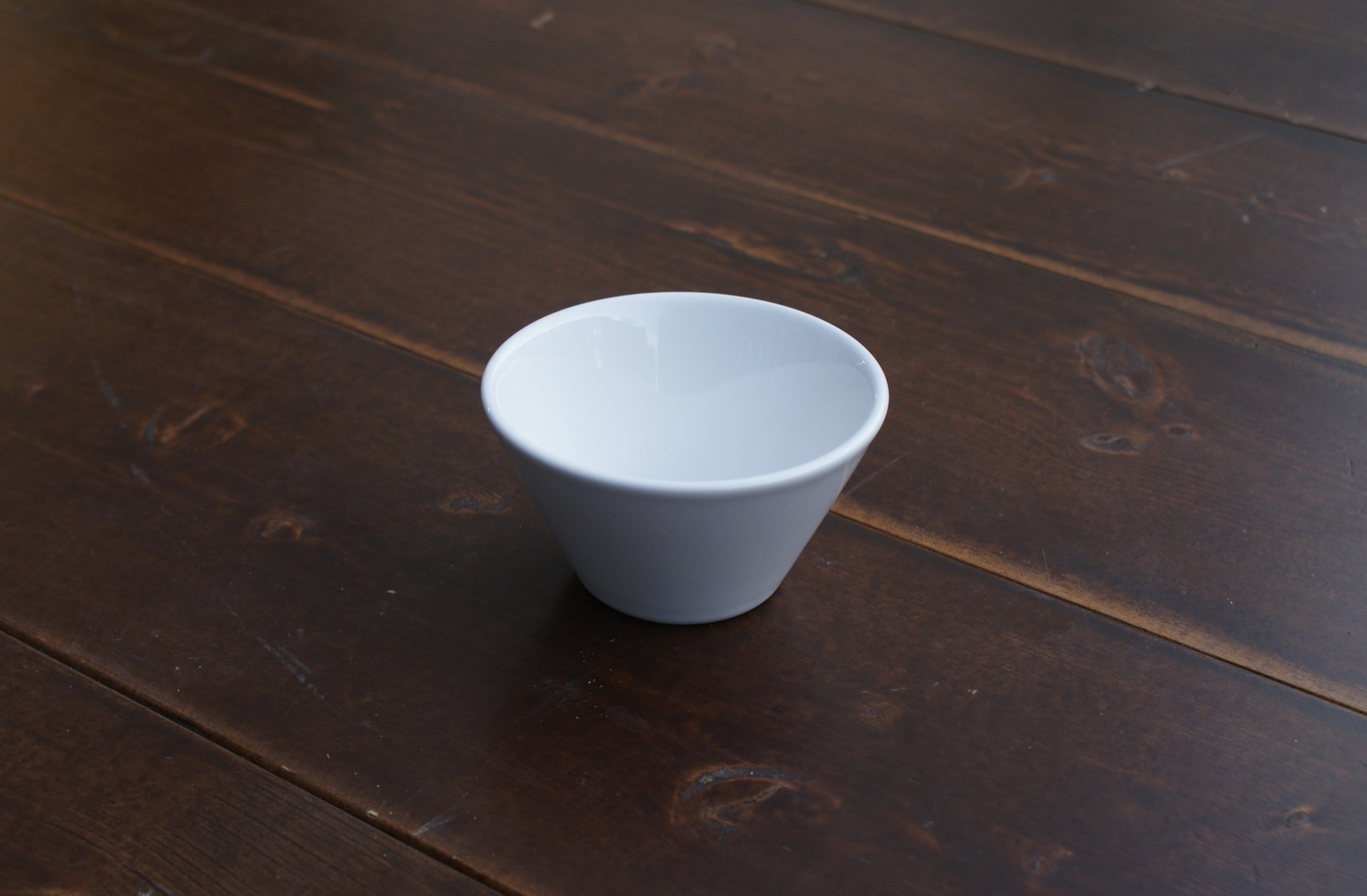 small white bouillon bowl on a wood table