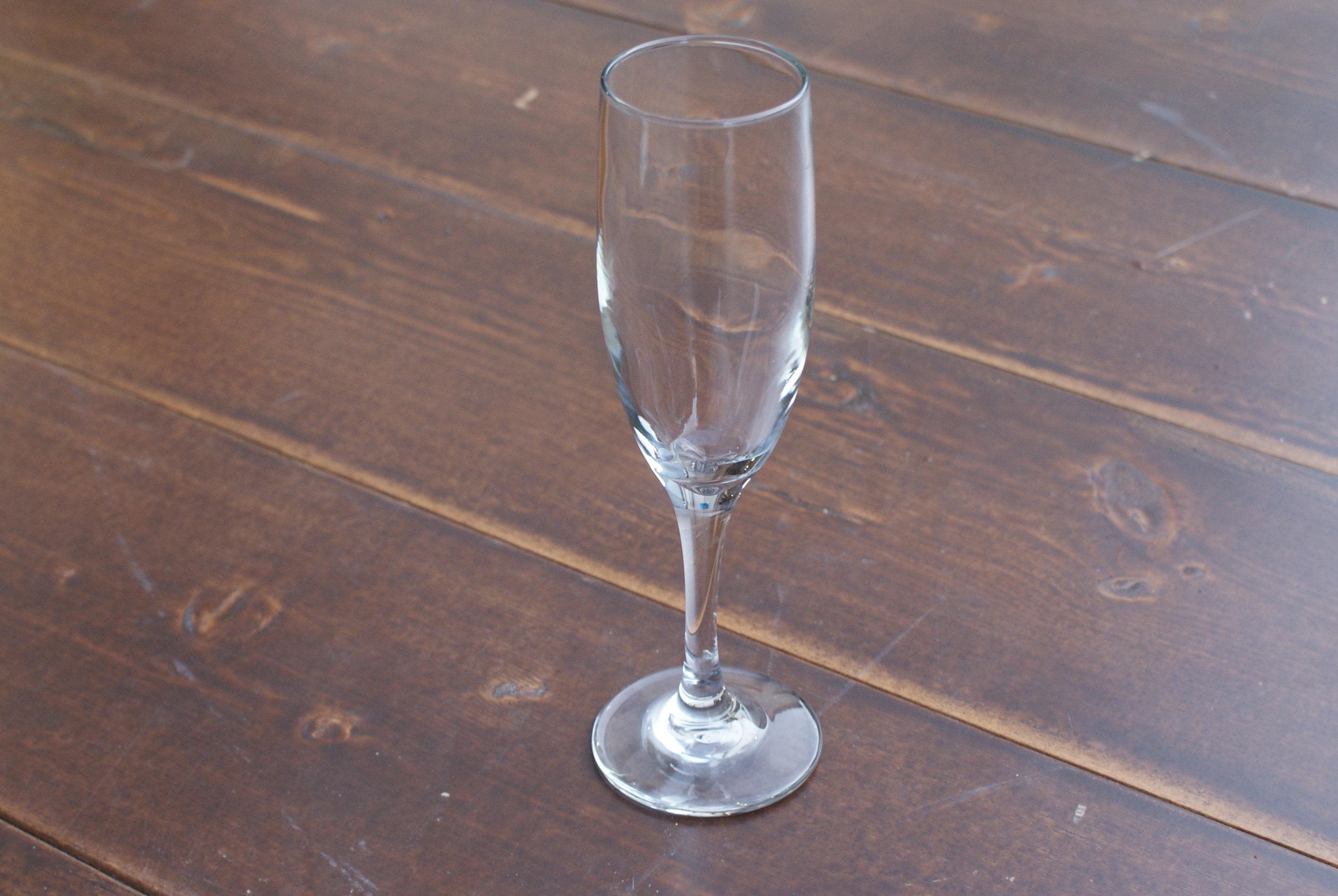 empty champagne flute on a wood table