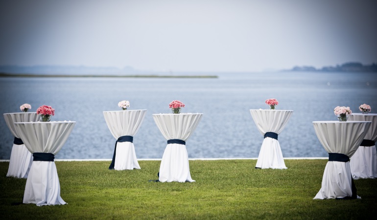 cocktail tables with white covers and pink flowers arrangement