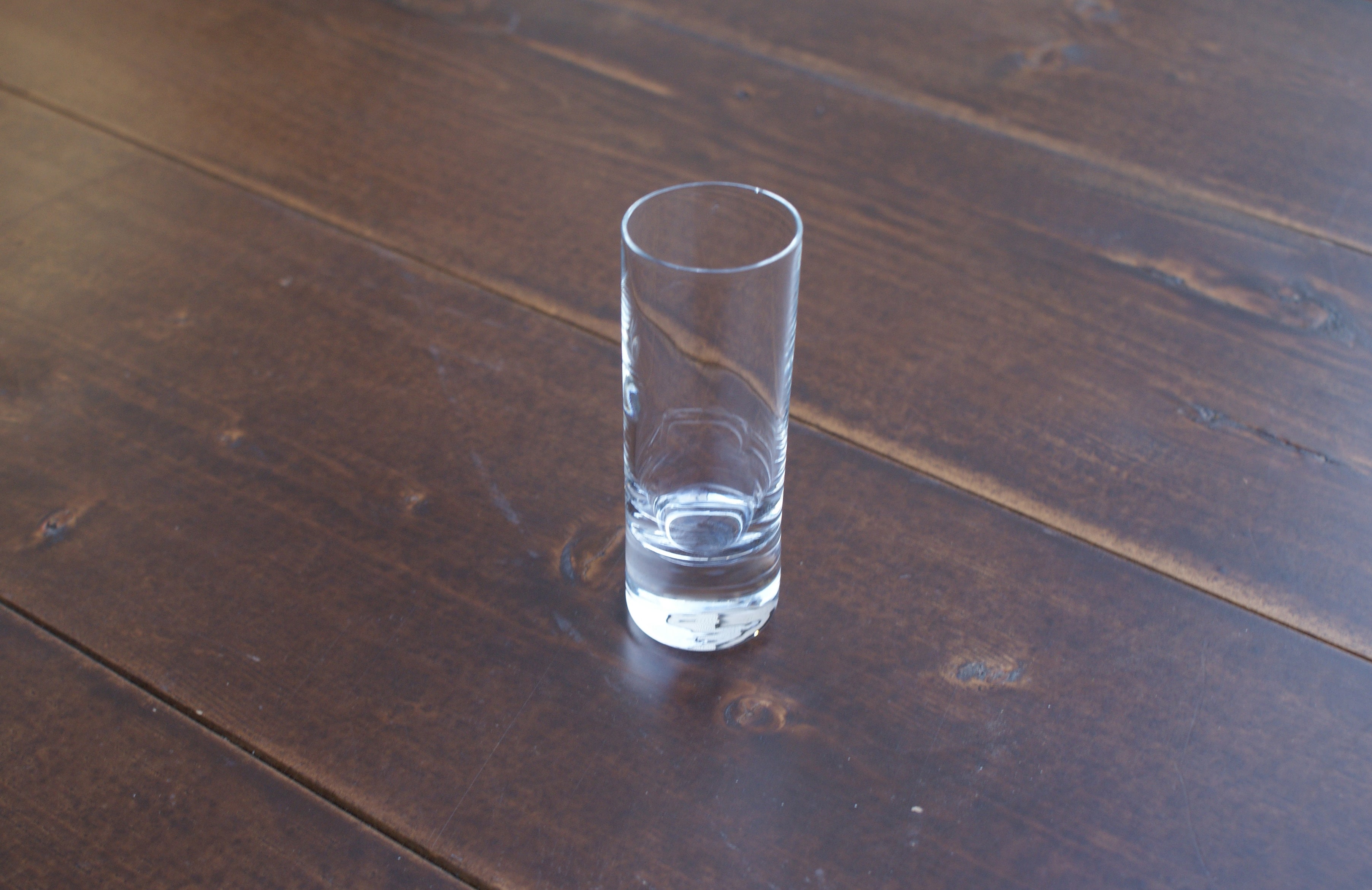 empty cordial glass on a wood table