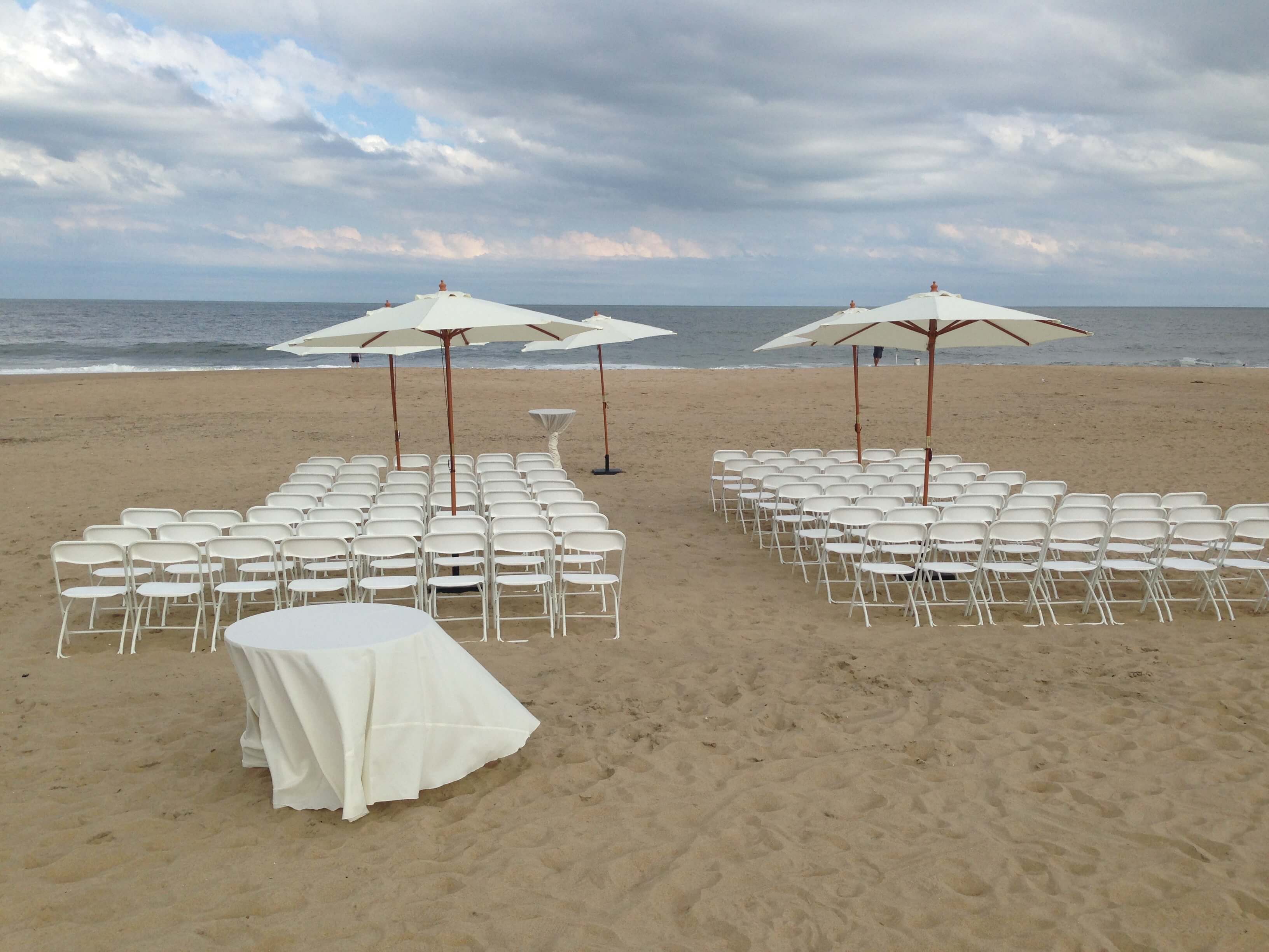 white folding chairs on the beach