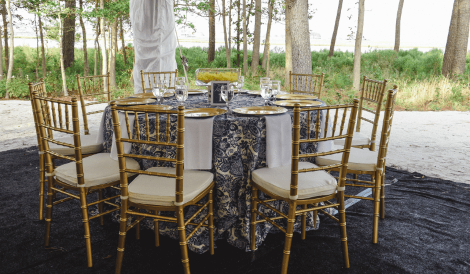 gold chiavari chairs with white cushions around a table