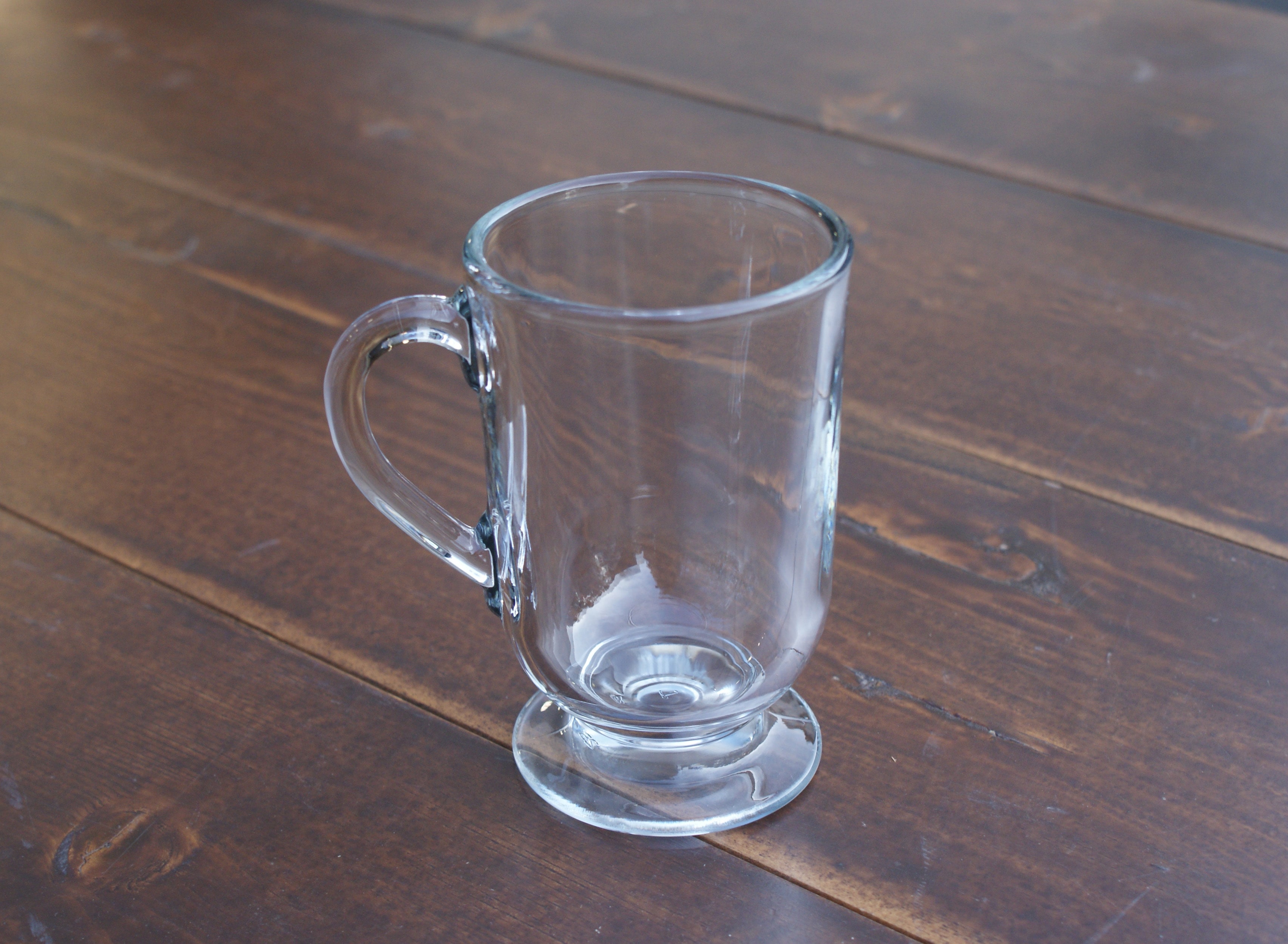 empty glass Irish coffee mug on a wood table