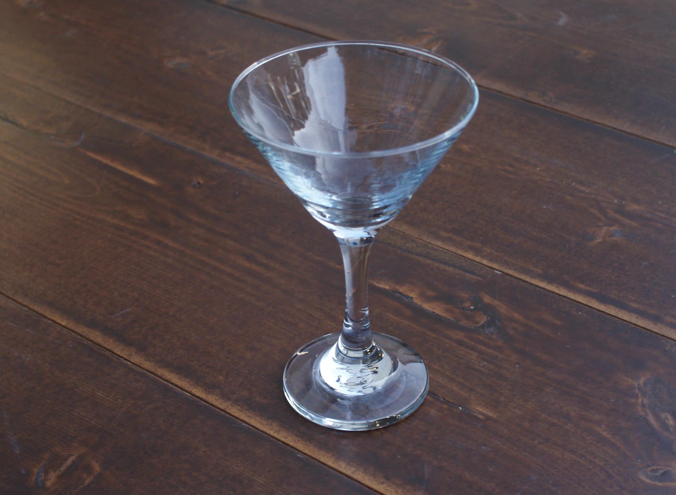 empty martini glass on a wood table