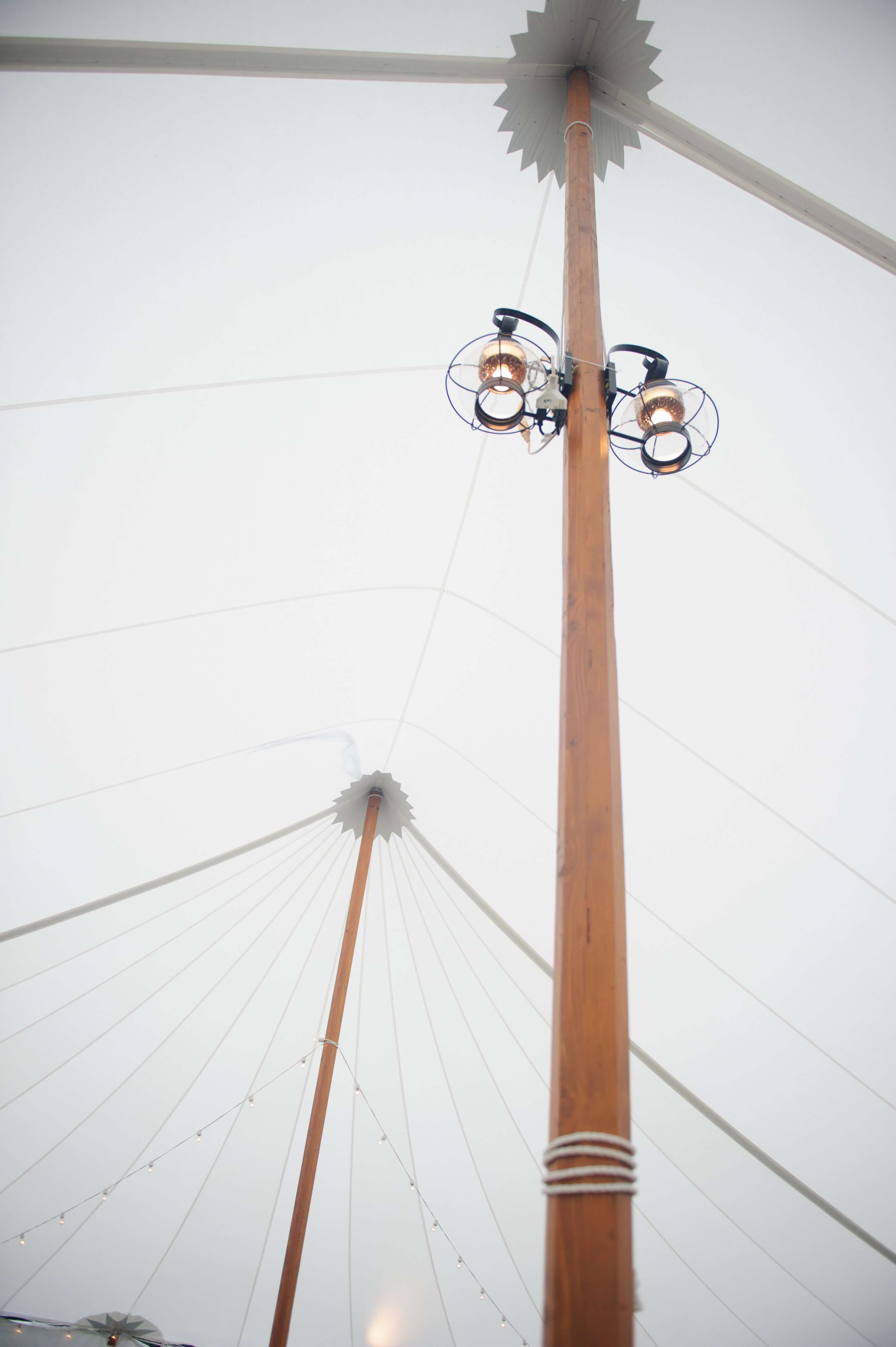two onion lamps on a wood beam in a white tent