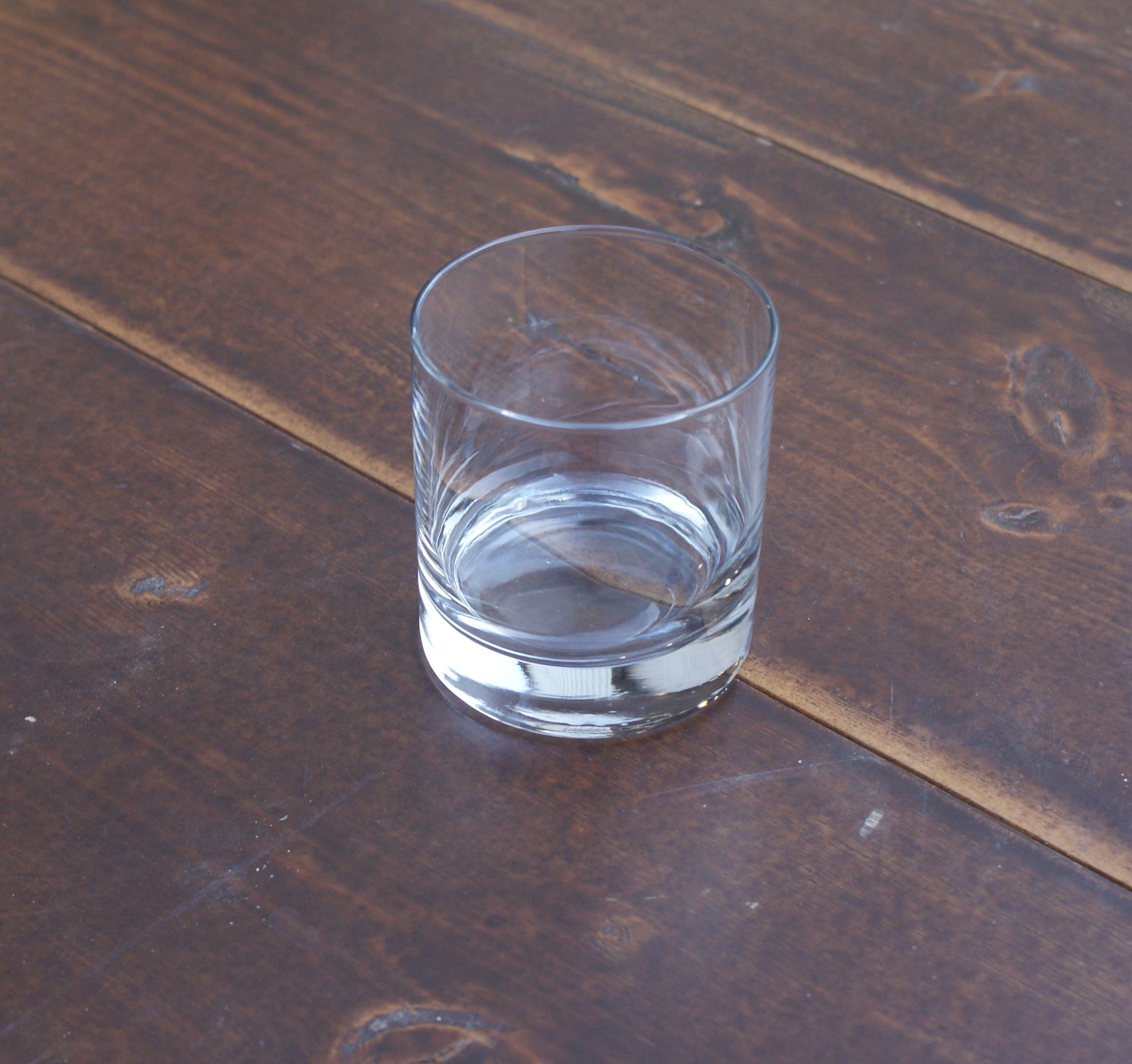 empty whiskey glass on a wood table