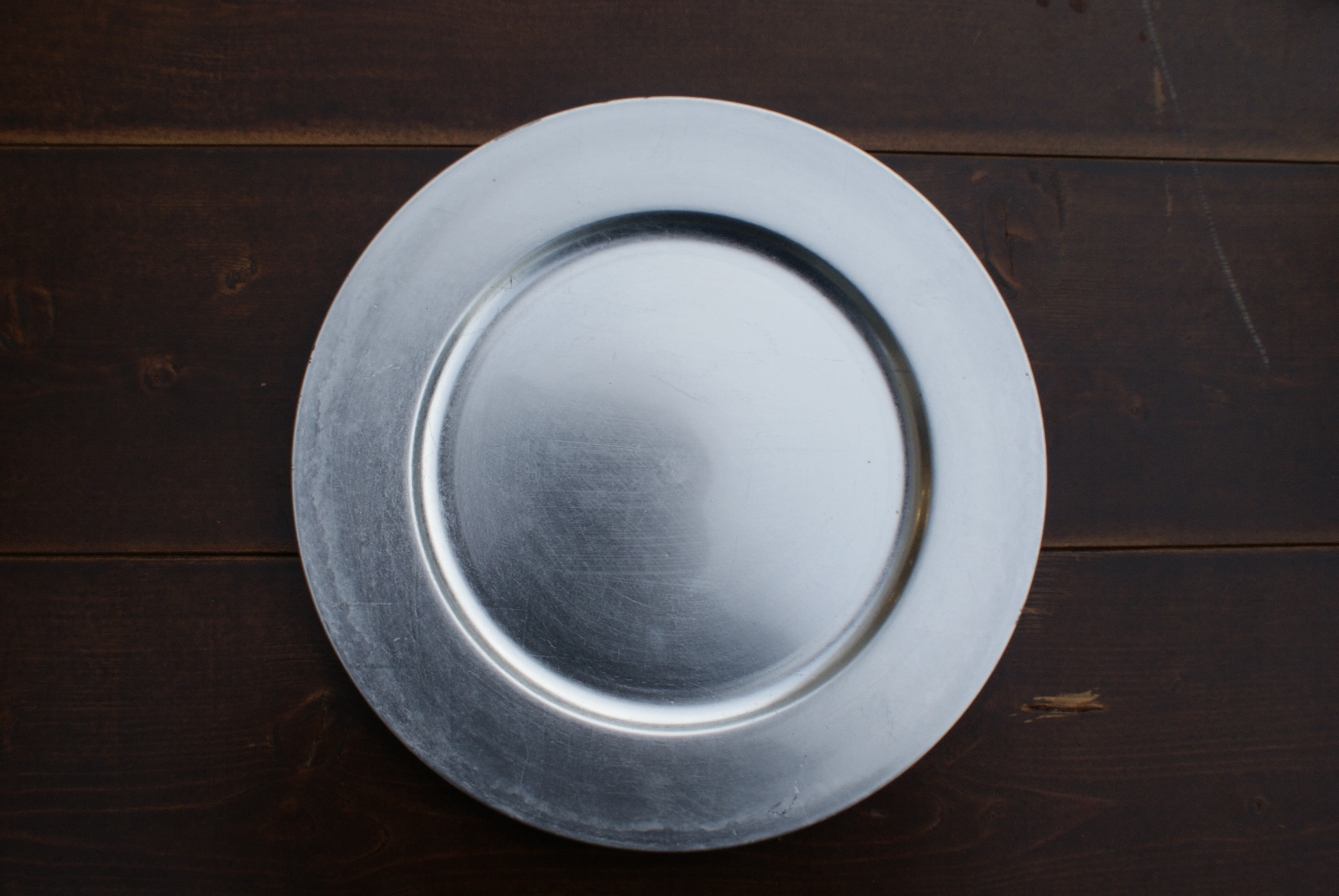 round silver plate on a wood table