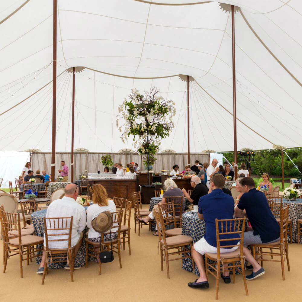 tables on sisal carpet under a white tent