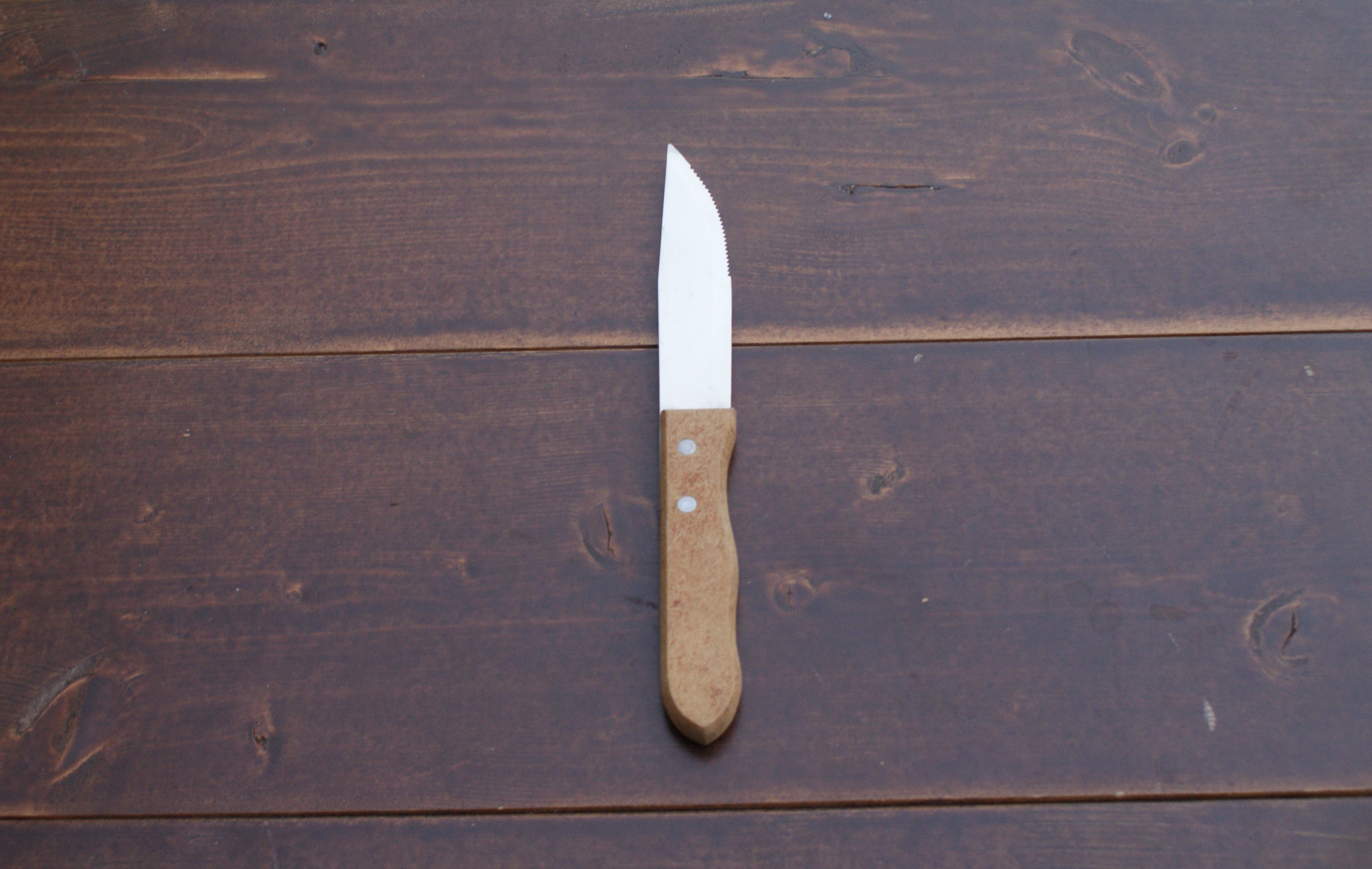 one steak knife on a wood table