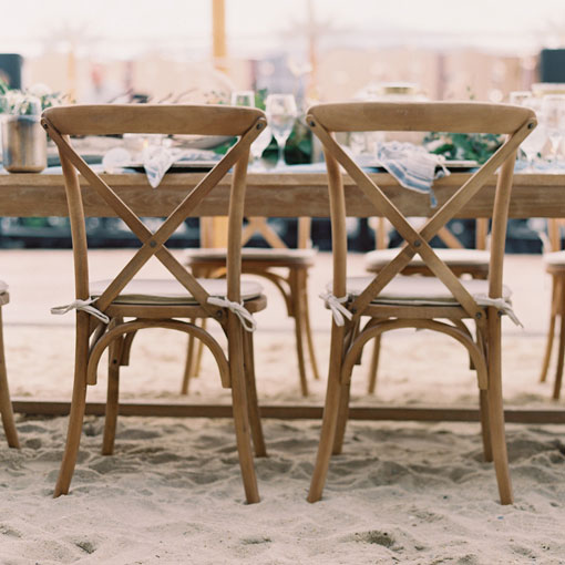 wooden chairs with cushions in the sand