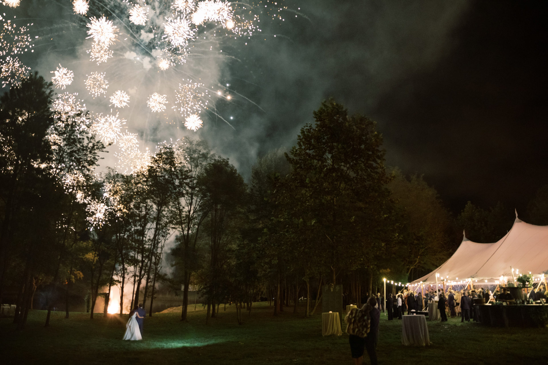 Large white tent for wedding reception and fireworks in the sky