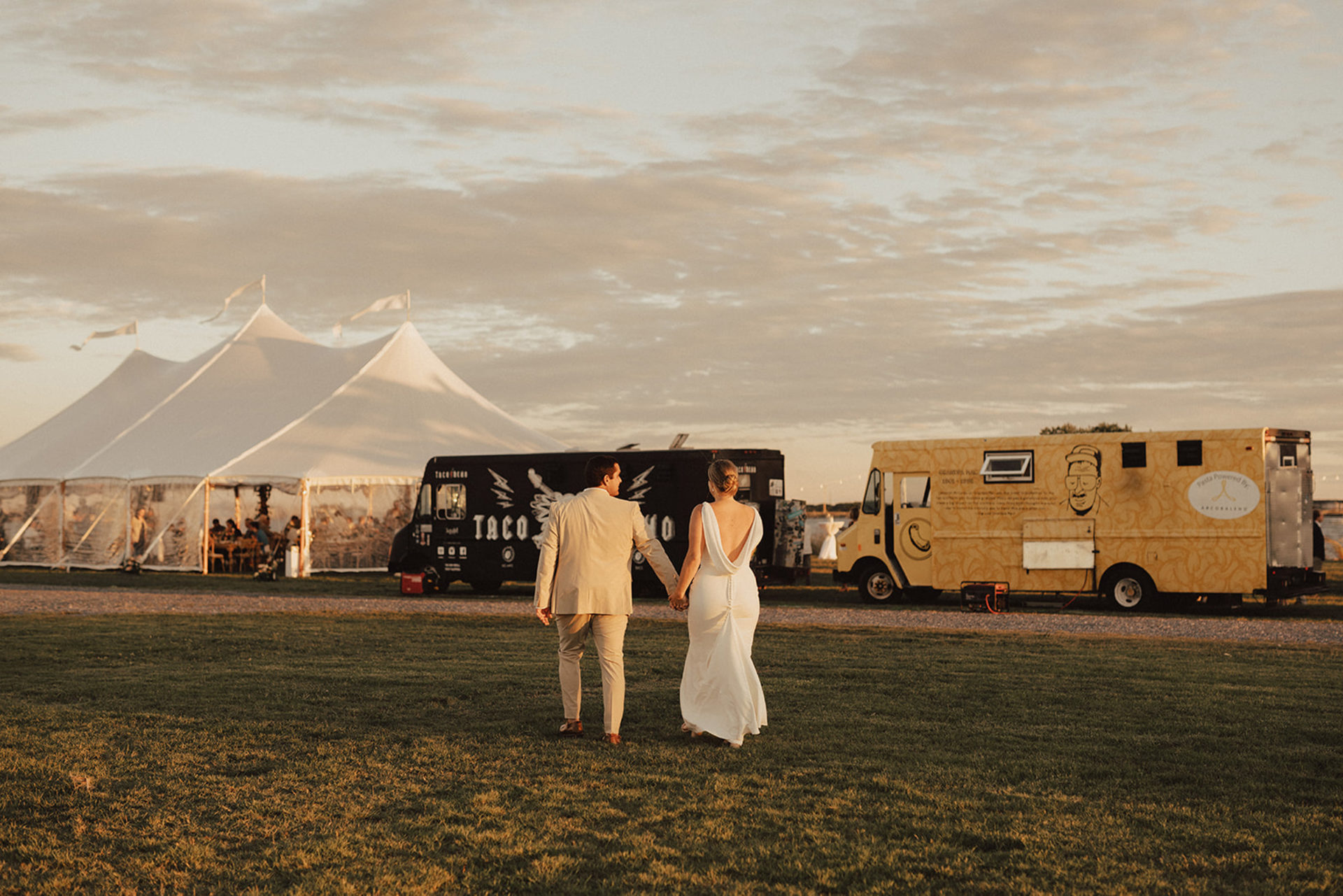 Large white tent for wedding reception and food trucks
