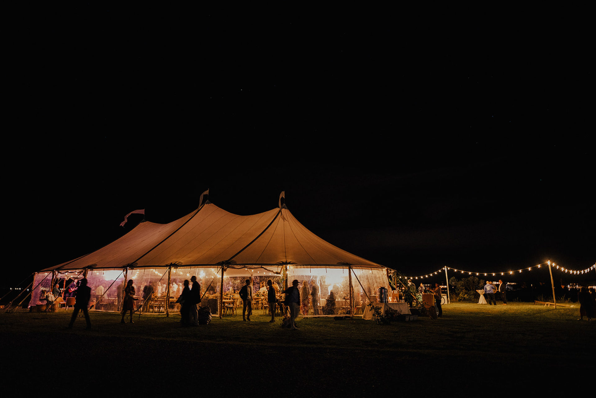 Large white tent with lights for wedding reception