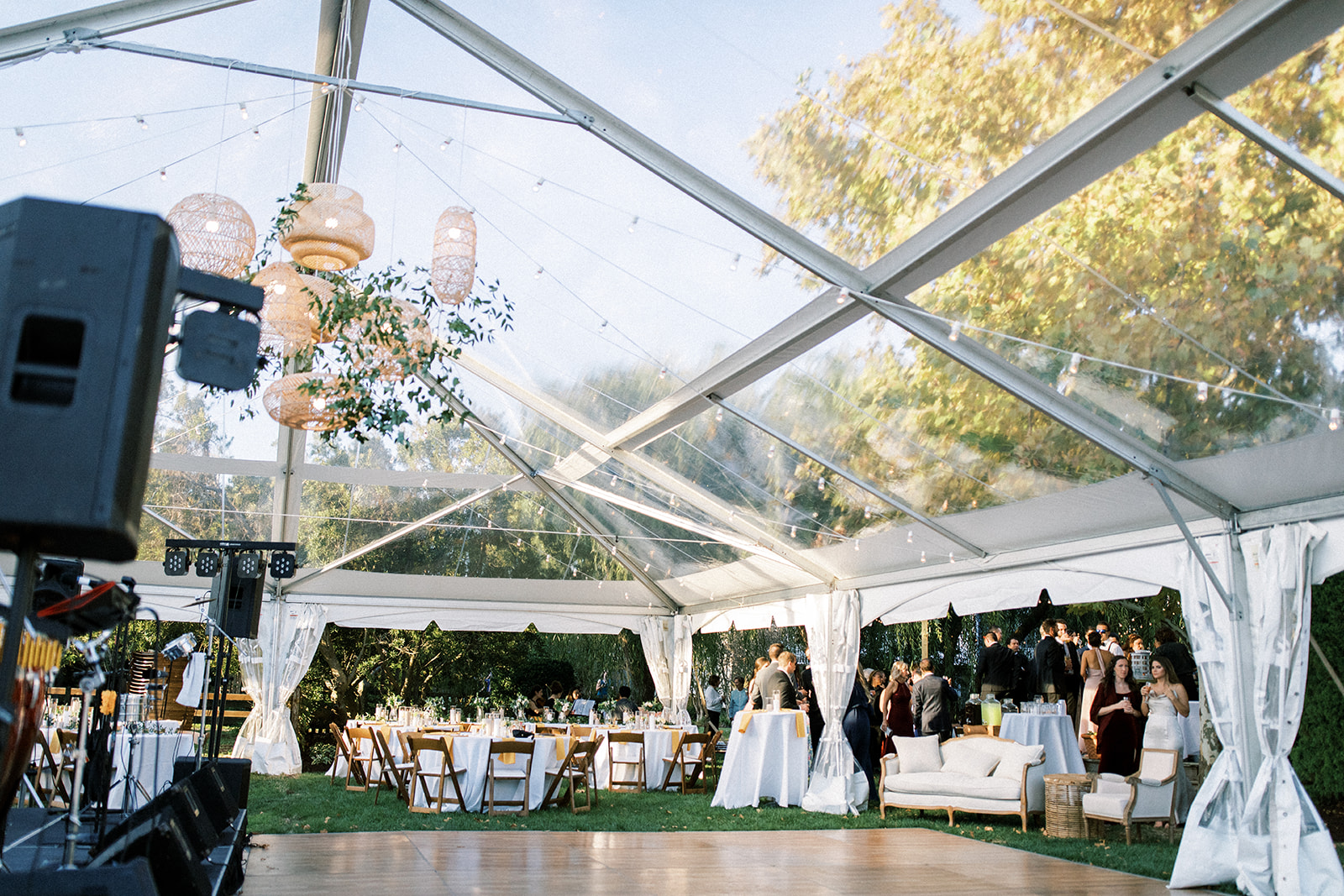 Clear Frame Tent over a wedding with a dancefloor and tables set up around